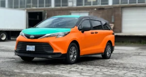 Oblique front view of a Toyota Sienna displaying a vinyl wrap